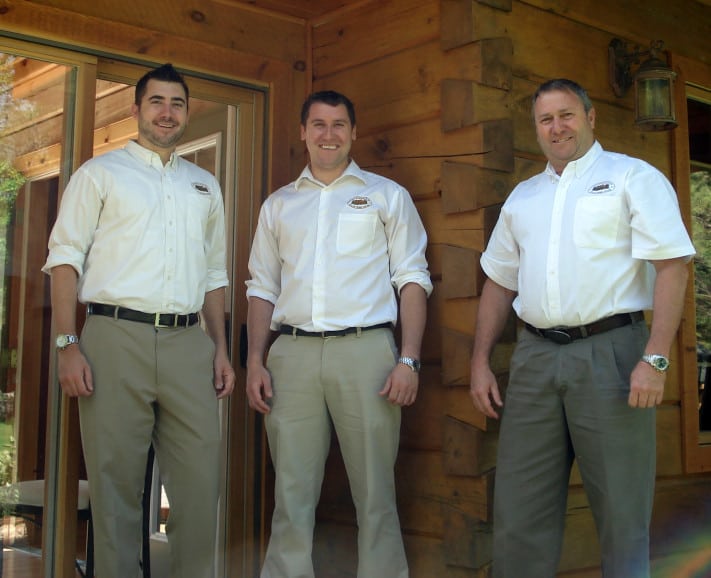Photograph of Rich, Andy and Rick Kinsman standing in on the porch of an 1867 Confederation Log & TImber Frame home